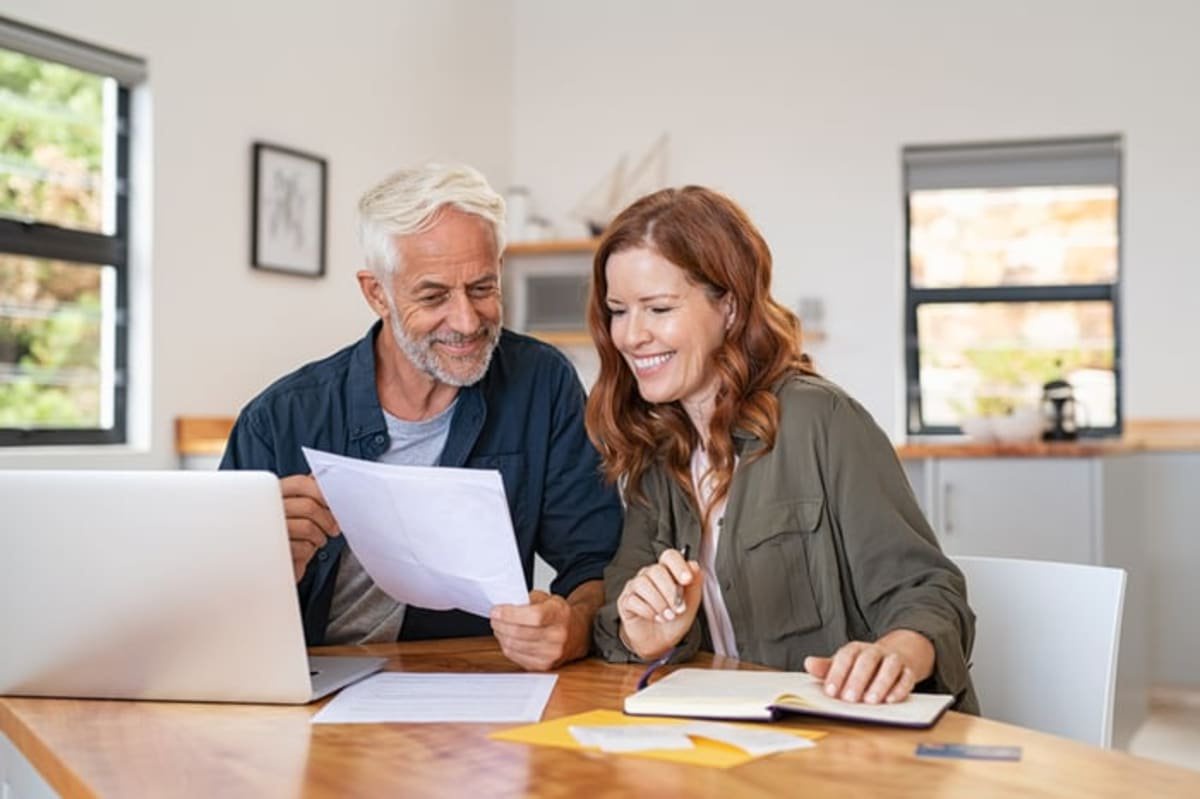 Smiling couple looking at documents together.