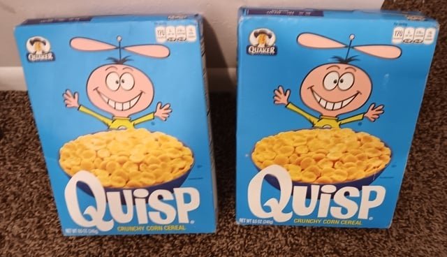 Two boxes of Quisp cereal with a cartoon alien character and a bowl of cereal on the front