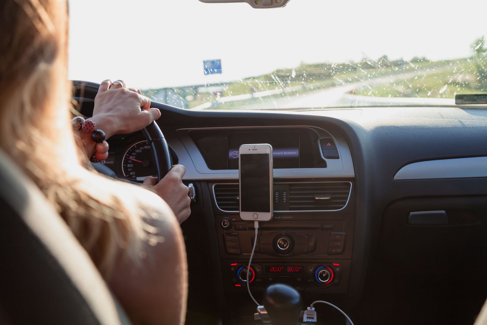 Driver with a smartphone mounted on the dashboard vent