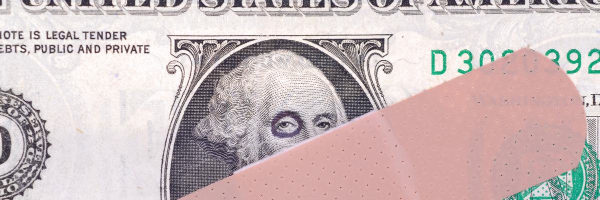 A close up of a dollar bill where Washington has a black eye and is partially covered in a bandage.