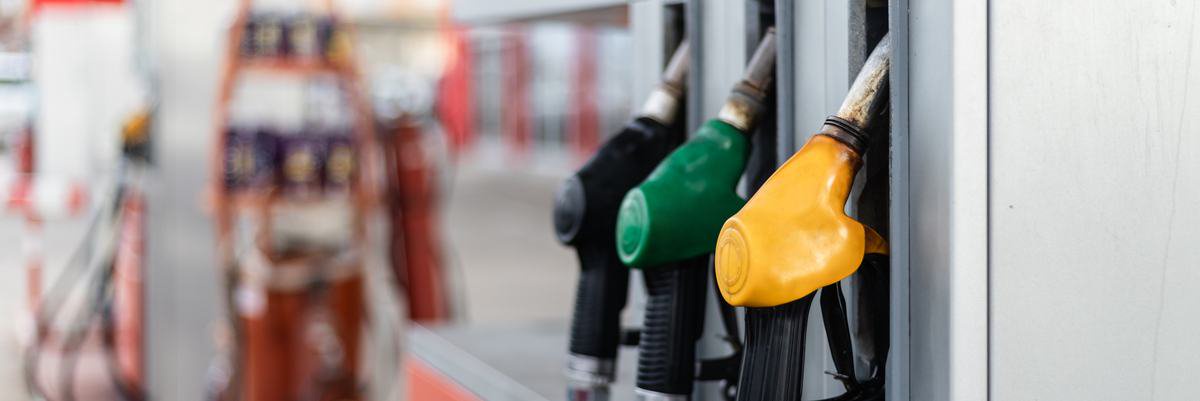 A gas station with three fuel pumps of varying colors.