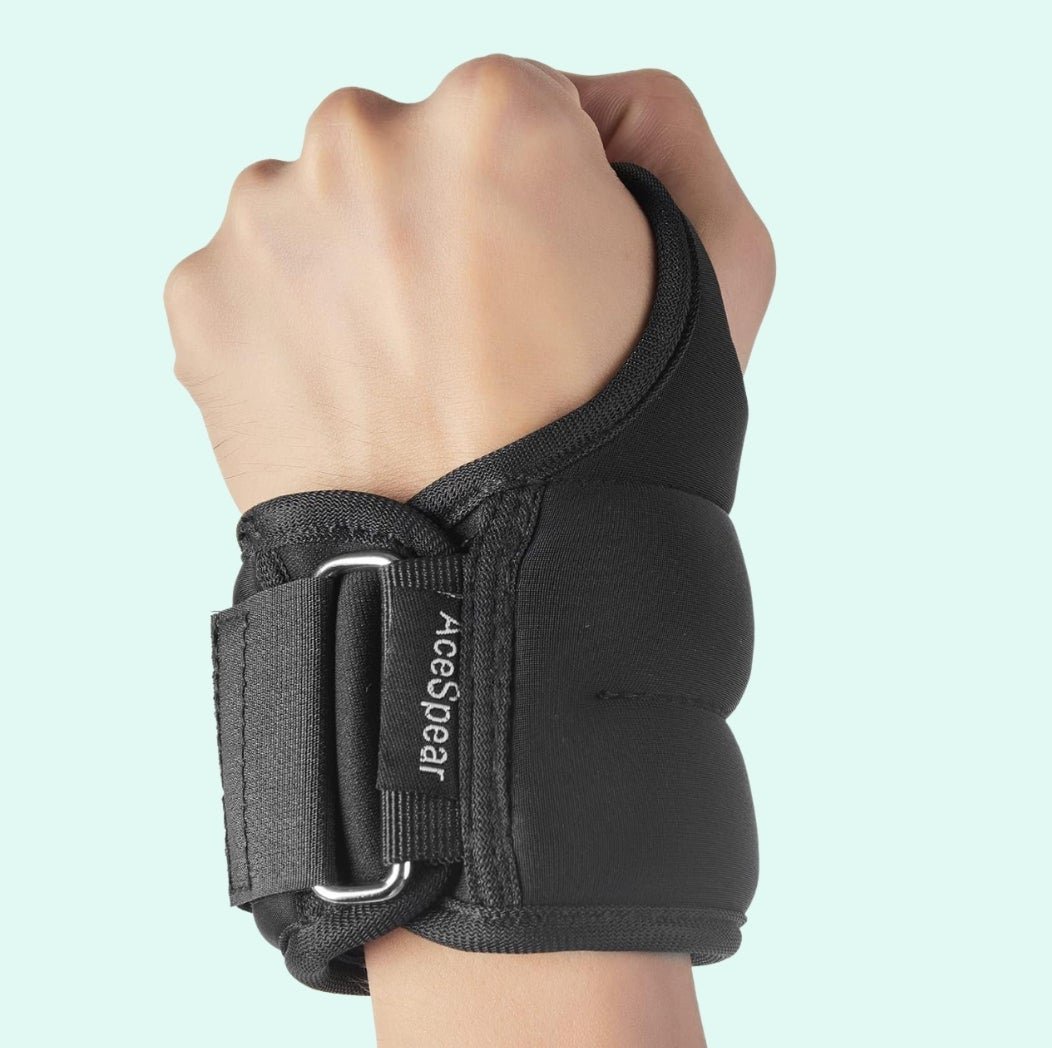 Hand wearing a black wrist support with adjustable strap; brand name visible