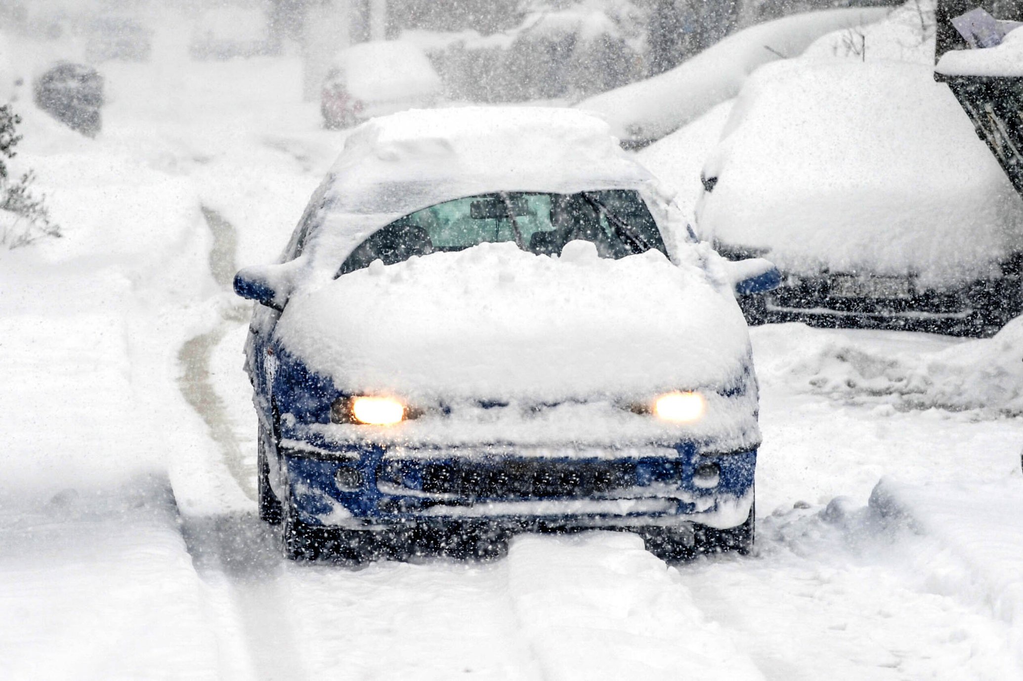 Driving a car covered in snow and ice