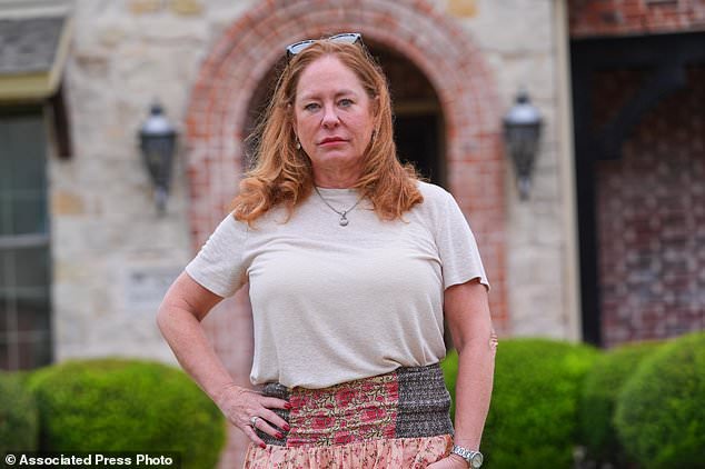 Liz Suder poses for a photo in front of her former home that was sold in Murphy, Texas, Tuesday, Oct. 13, 2026. (AP Photo/LM Otero)