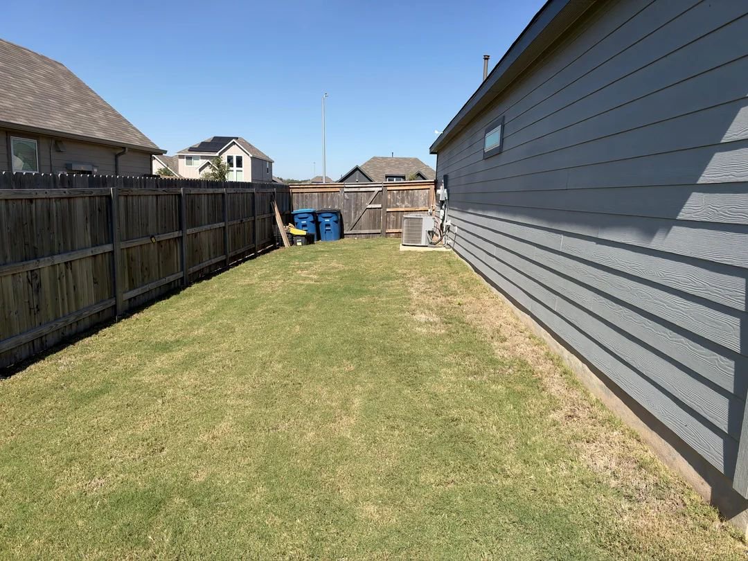 A generator in a fenced yard. 
