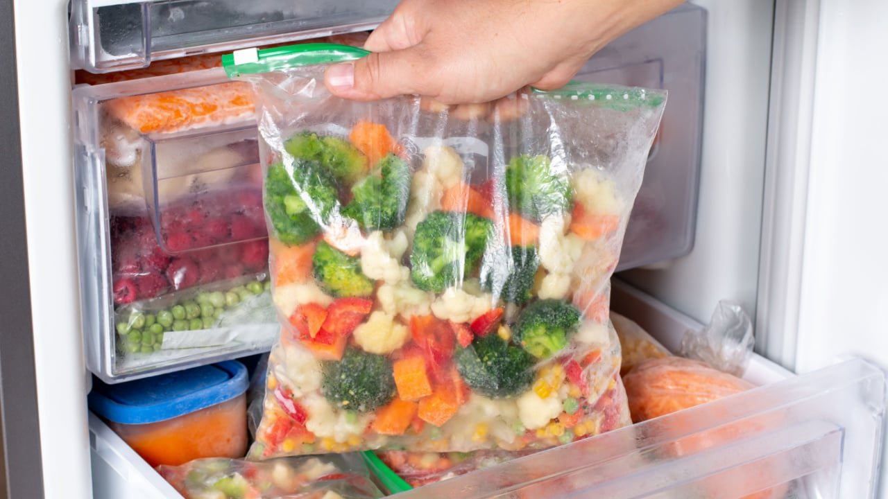 Plastic bags with different frozen vegetables in refrigerator. Food storage
