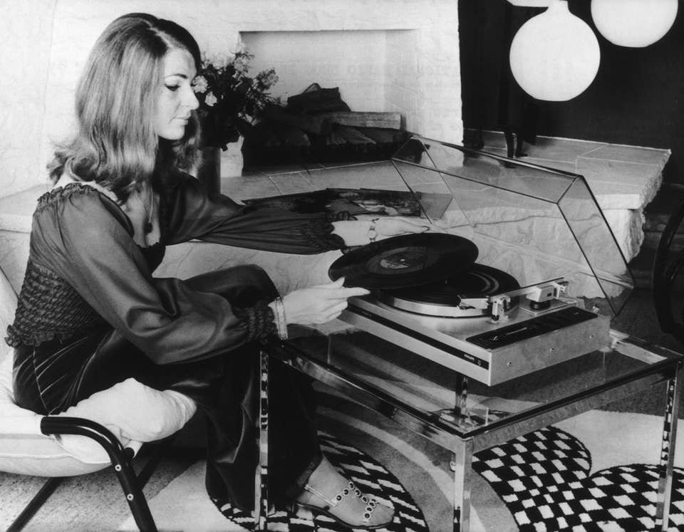 A woman using an automatic record player made by Philips, at the International Radio Show in Berlin, circa 1974. The turntable automatically places the pick-up on the record, lifts it off again when it reaches the end of the side and stops the motor. 