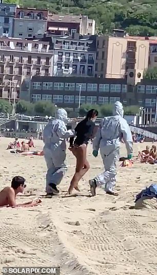 Female surfer is dragged away by hamzat-officials and arrested on Spanish beach after going in the sea while infected with COVID-19 (photos)