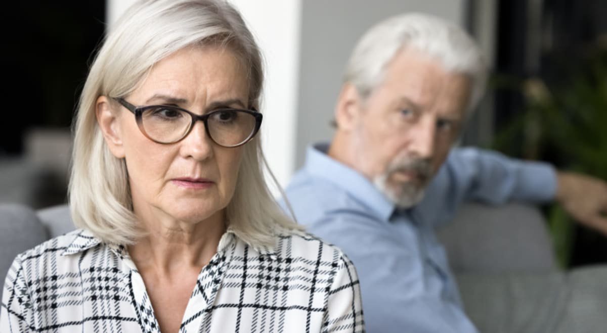 Concerned older woman with black-frame glasses.