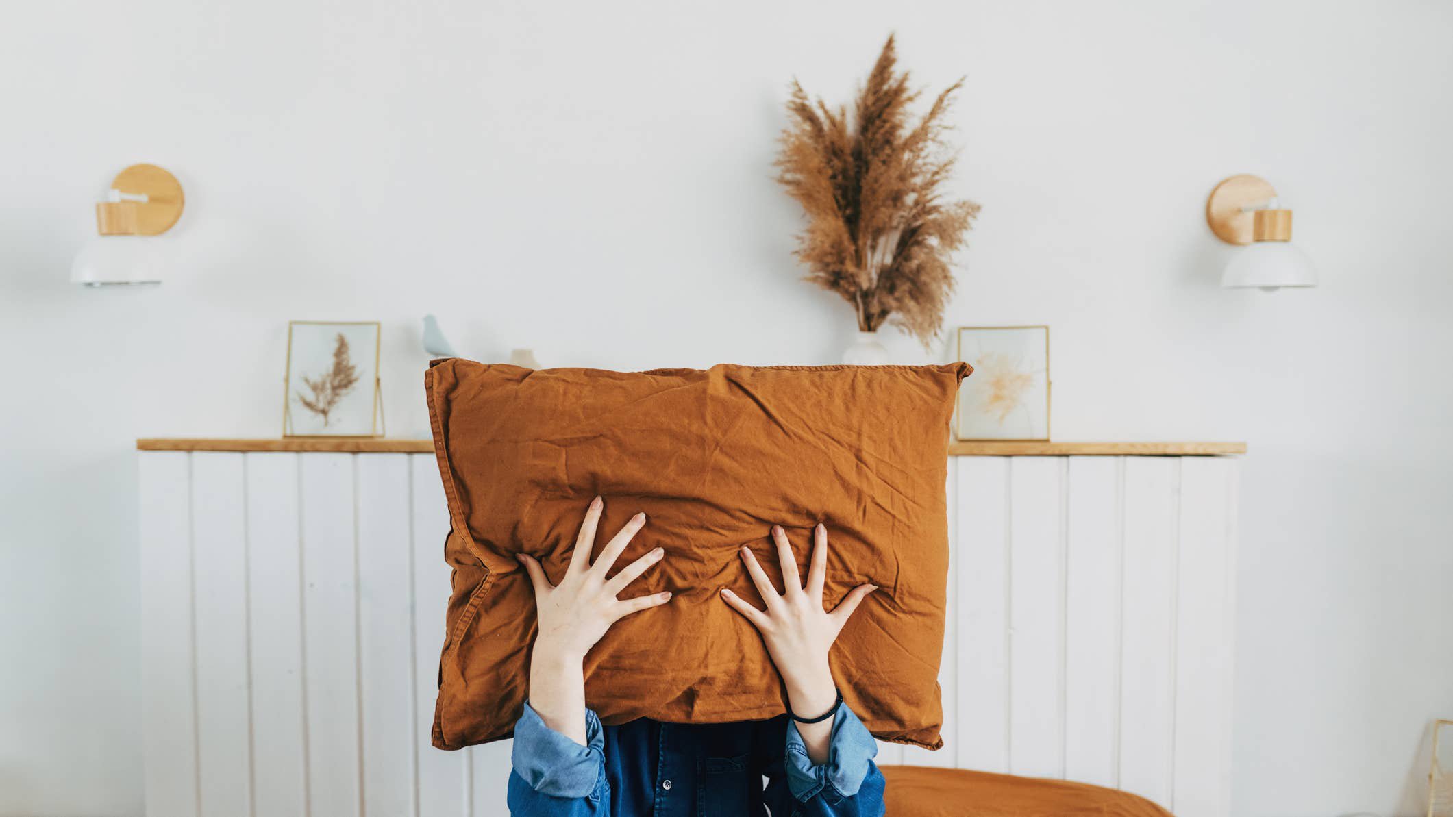 Woman with pillow over her head.