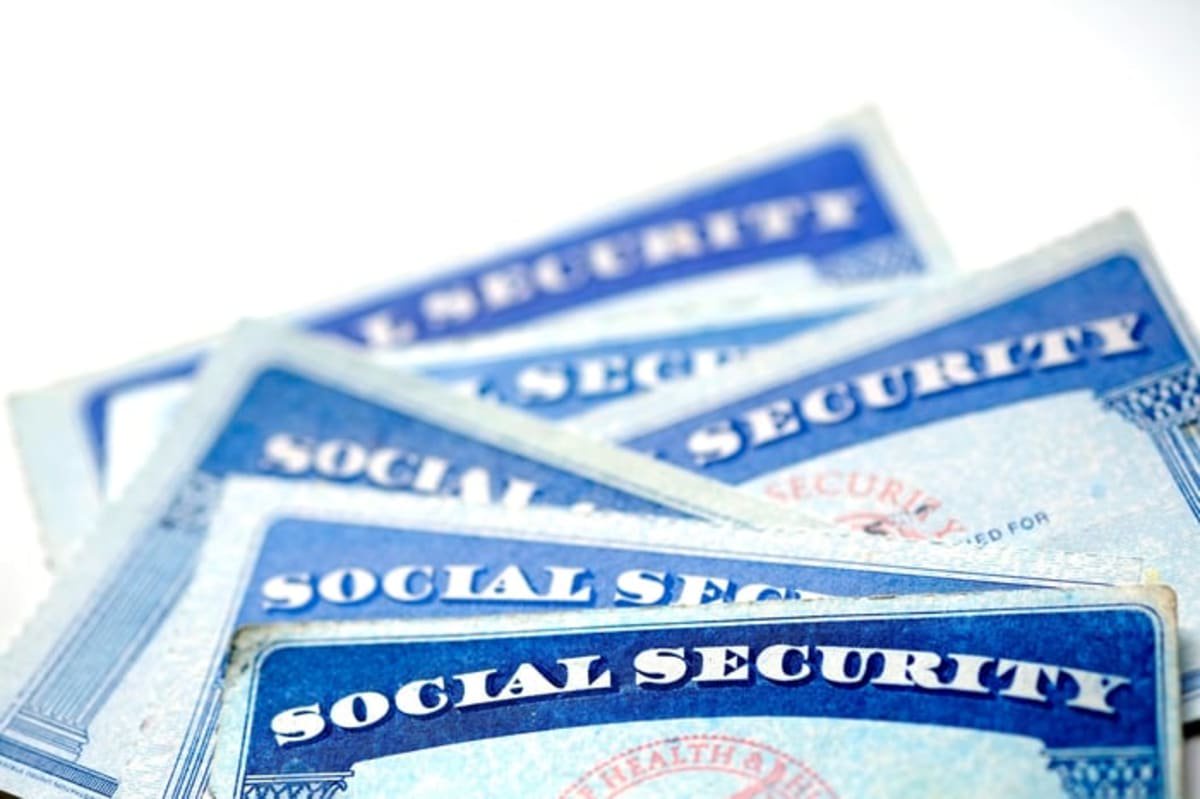 Close-up of overlapping U.S. Social Security cards on a white background