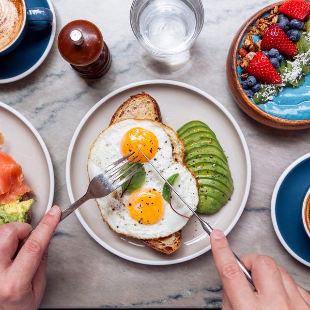 Person eating healthy colourful breakfast at a cafe, high angle view