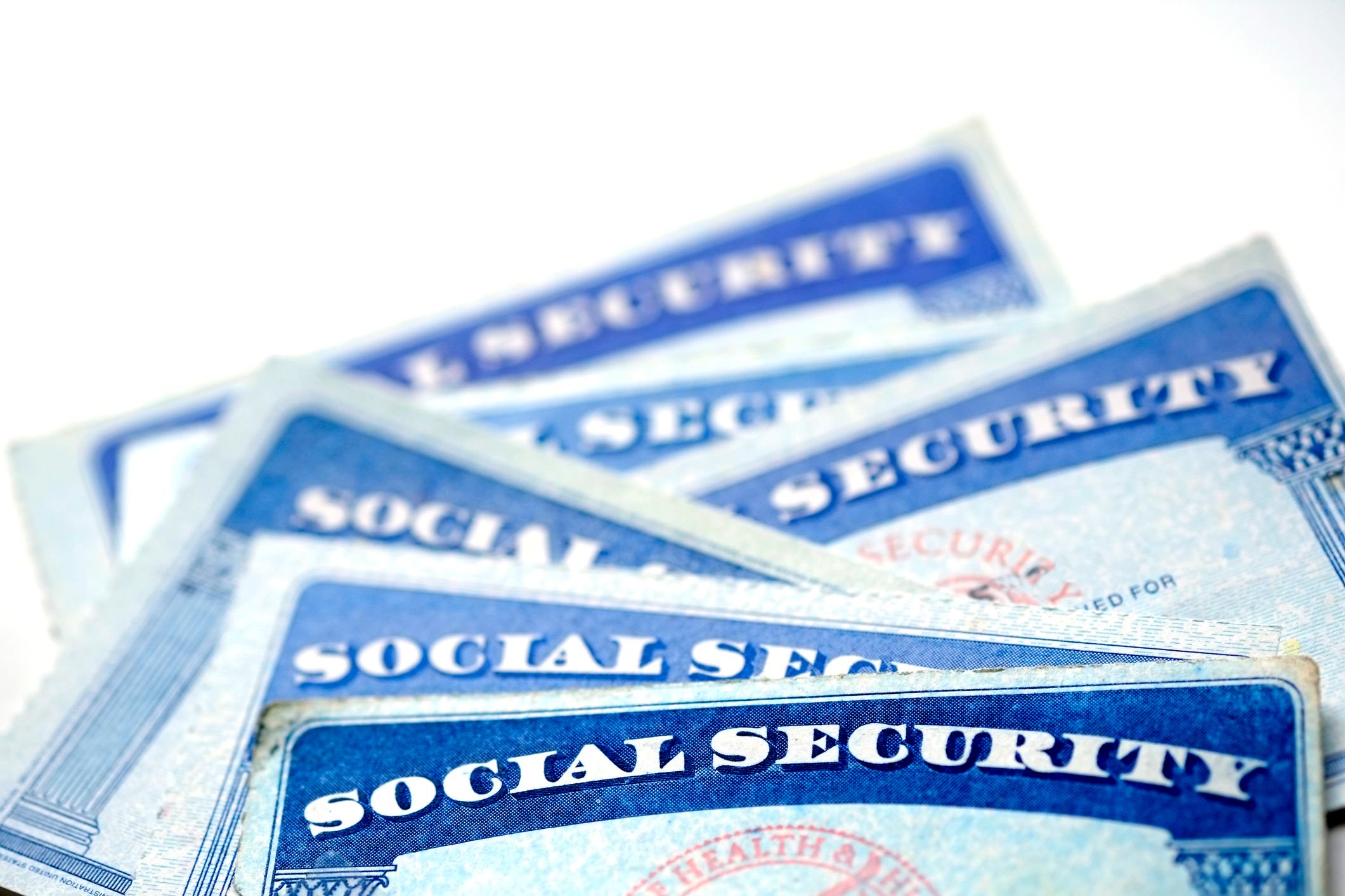 Close-up of overlapping U.S. Social Security cards on a white background