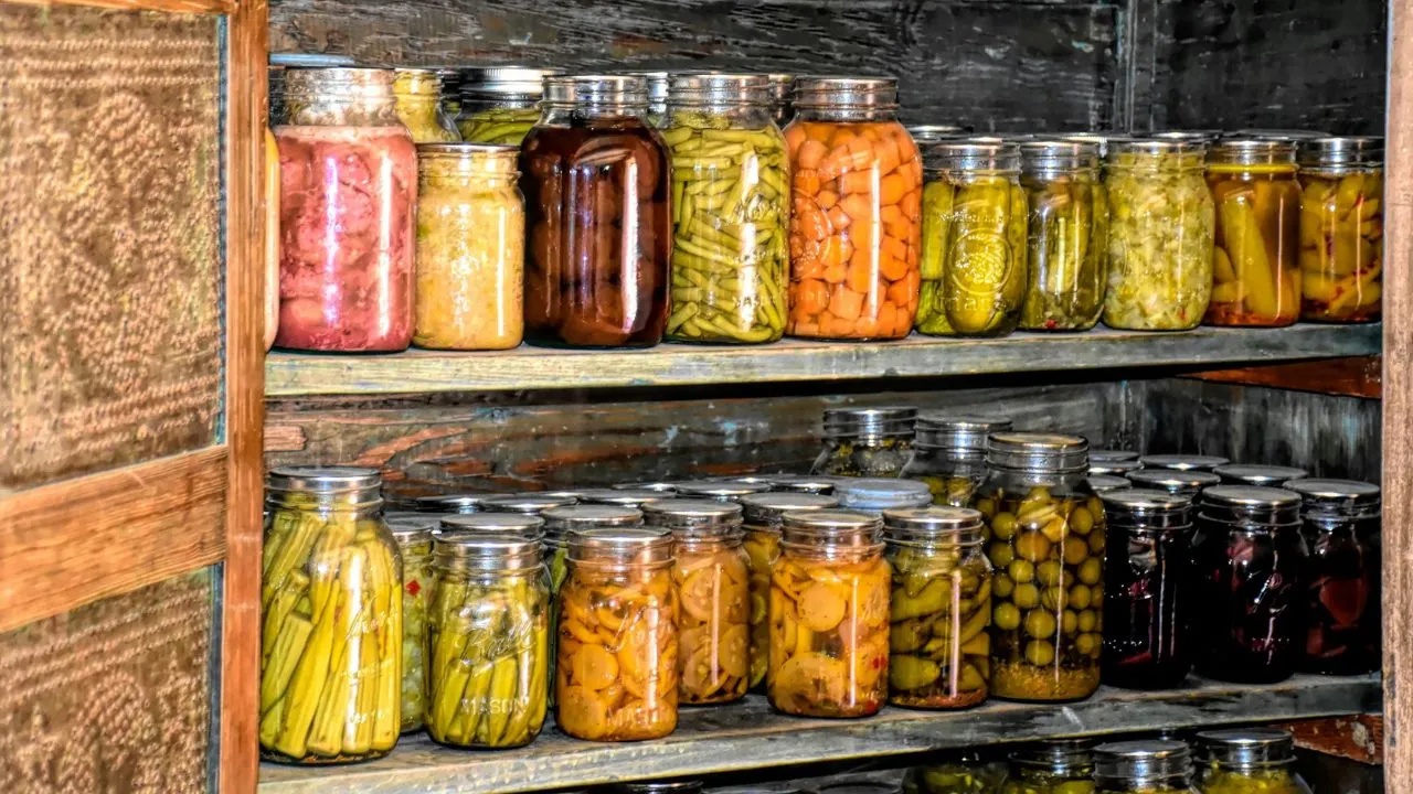 A wooden shelf filled with lots of jars of food.
