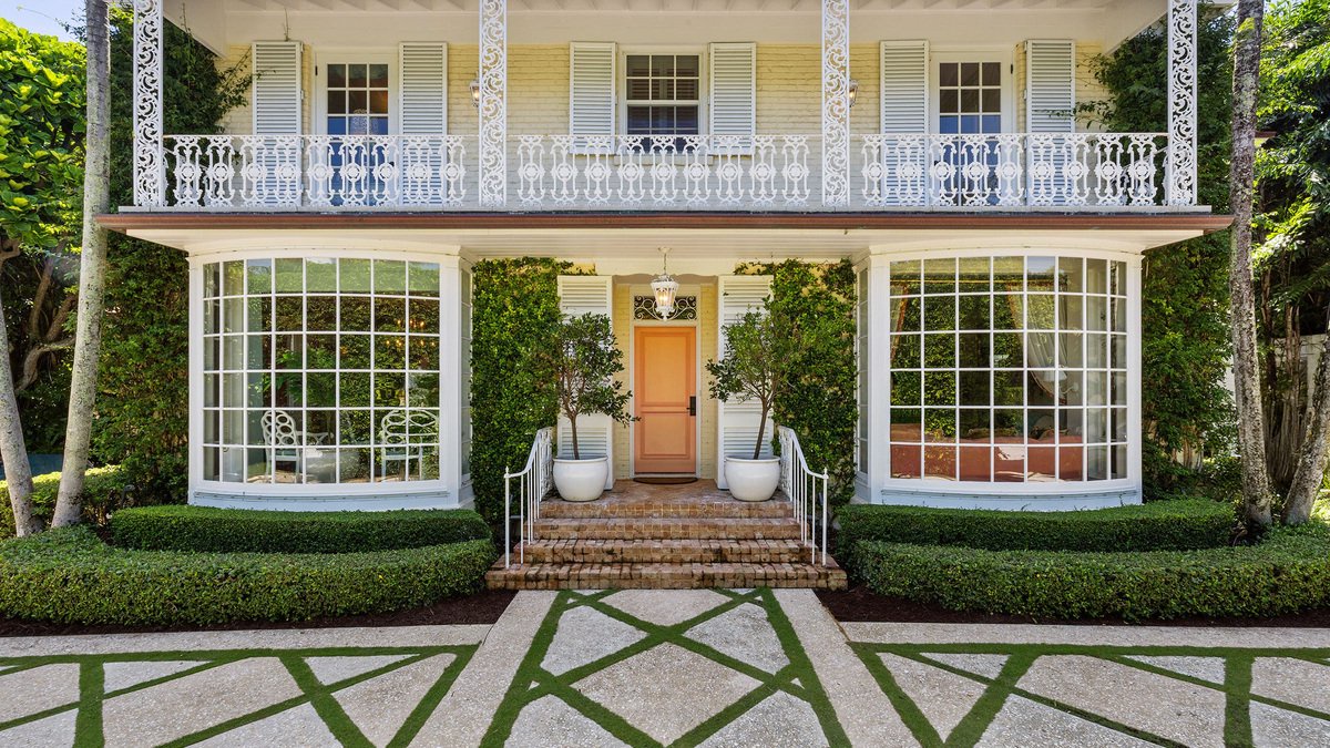 This Palm Beach home has two bow windows flanking the front porch.