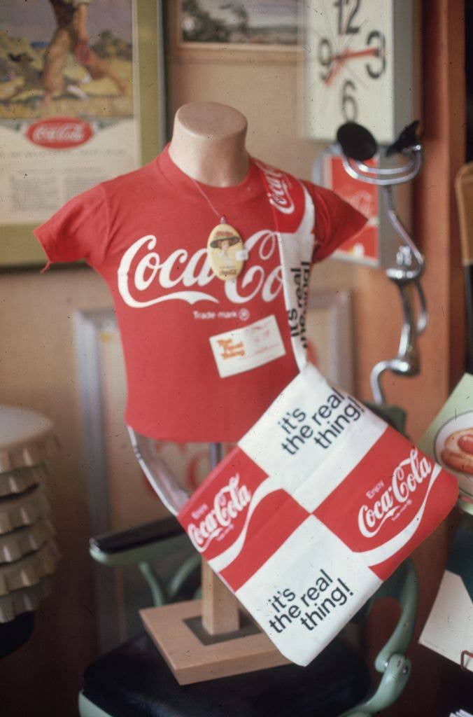  A T-shirt with the Coke logo on display at 'The Real Thing', a shop selling Coca-Cola merchandise and memorabilia.  