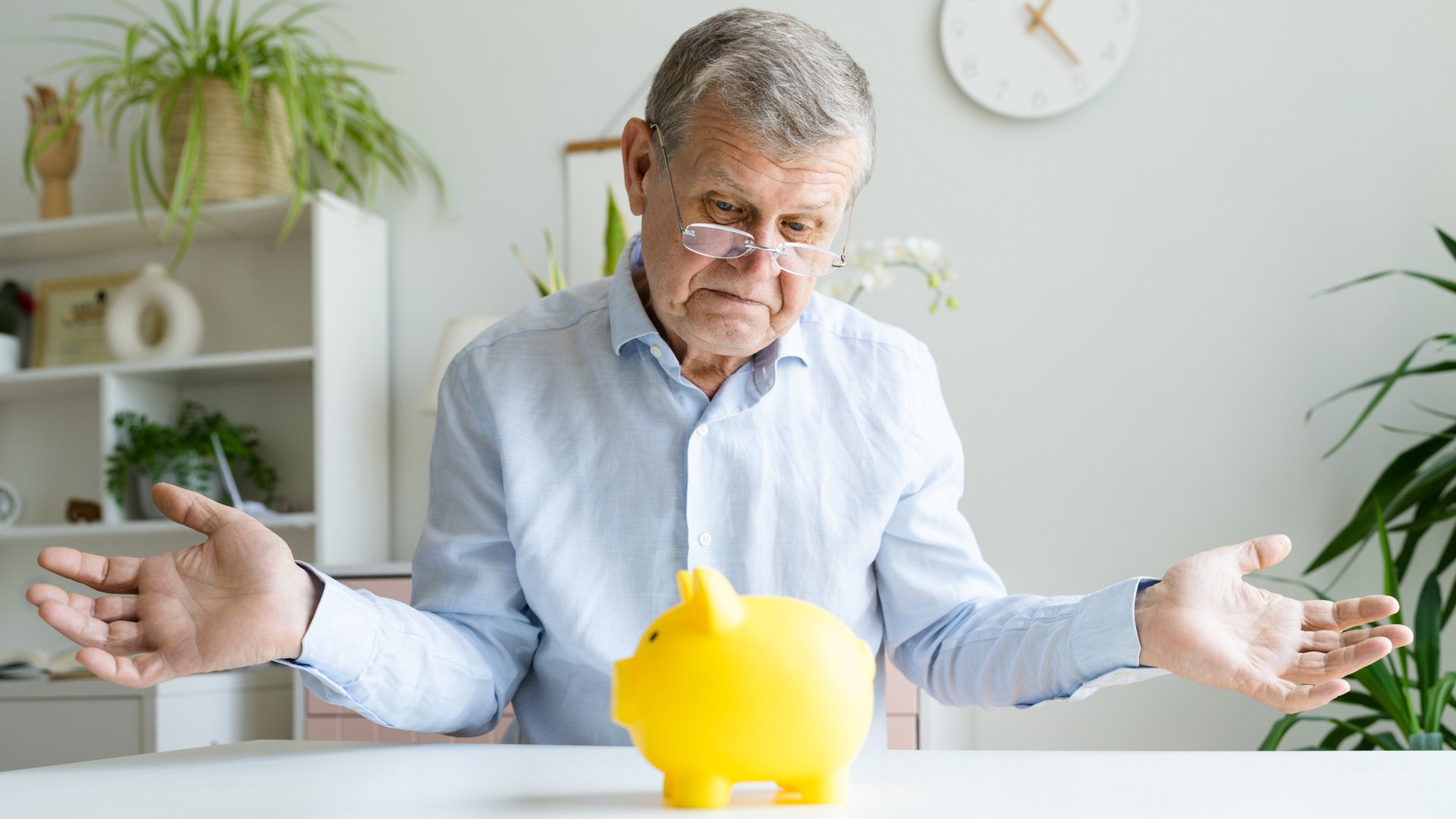 Discover Frustrated senior man saving money in a piggybank