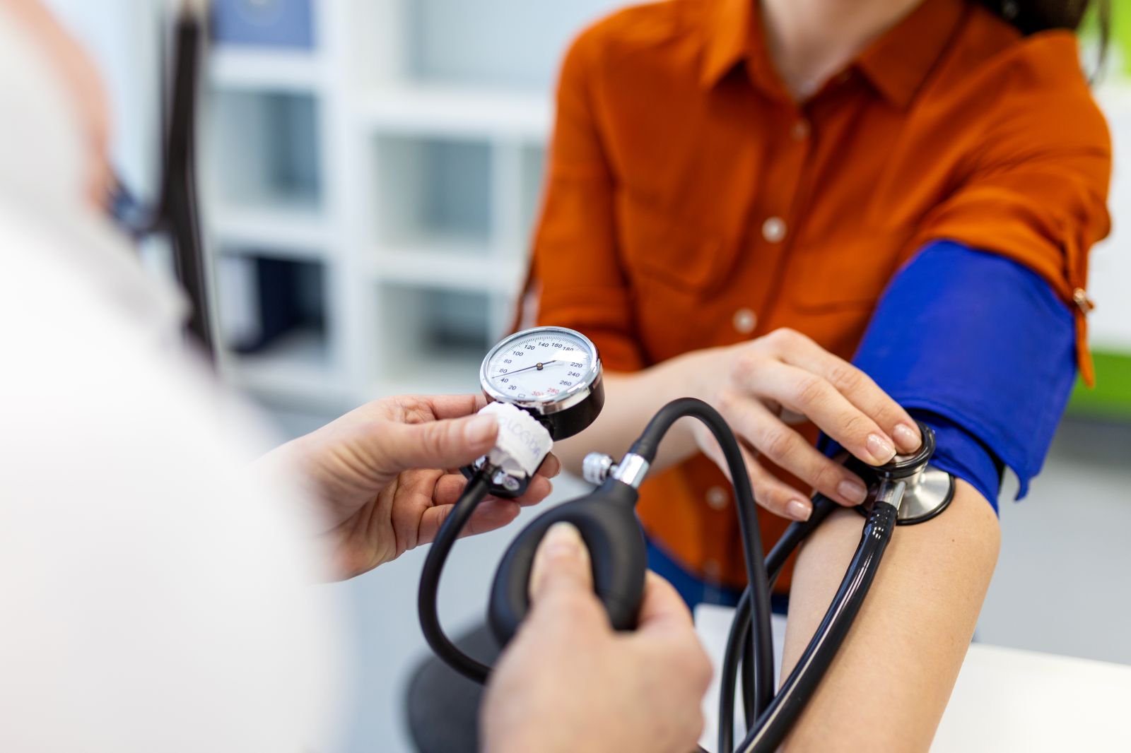 A doctor checks a patient's blood pressure.