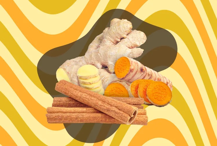 Ginger turmeric and cinnamon arranged together on a yellow and orange wavy background