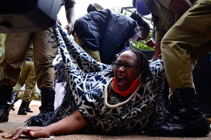 Stella Nyanzi (C), a prominent Ugandan activist and government critic, being aggressively arrested by police officers.