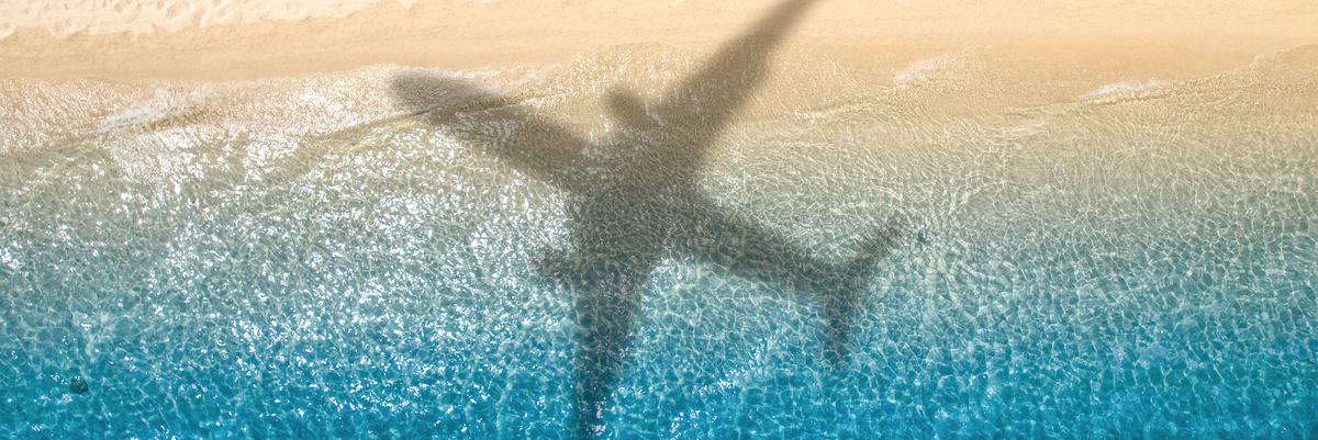 Shadow of an airplane flying over the beach.