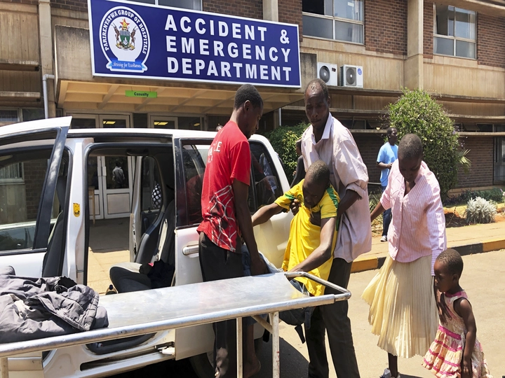 FILE: A family brings a sick relative to Parerenyatwa Hospital in Harare, Monday, Oct, 14, 2019.