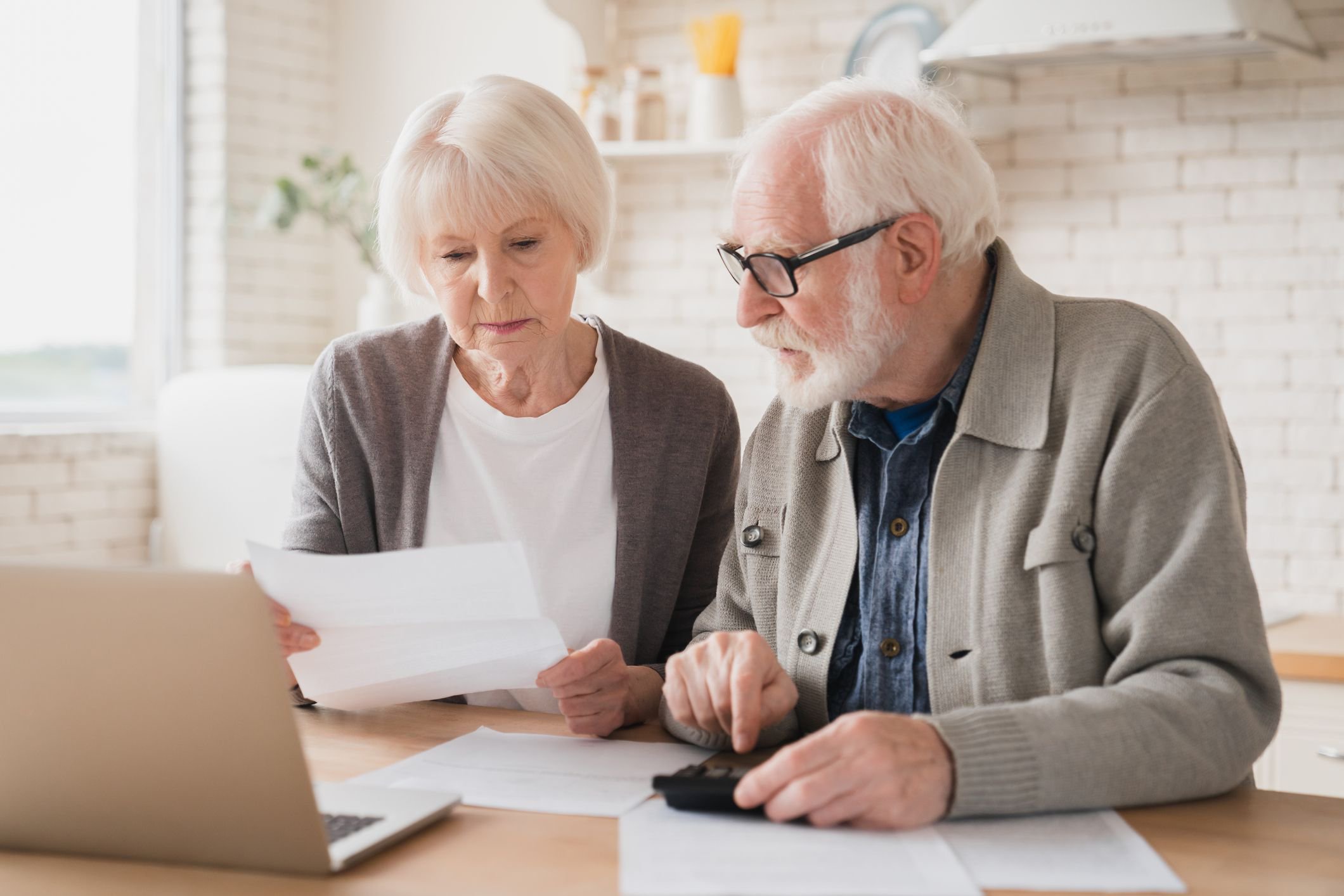 Two people at a laptop with documents