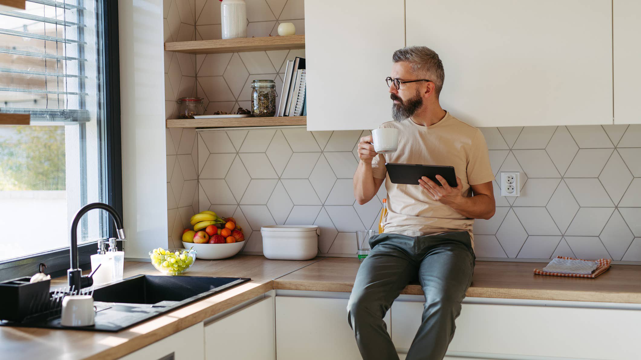 Man eating breakfast sitting on counter.