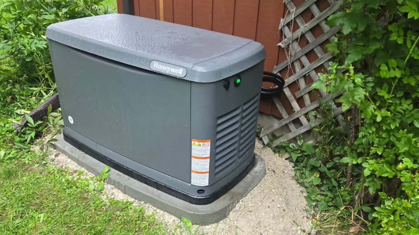 A generator placed beside a house with greenery and a wooden trellis in the background.