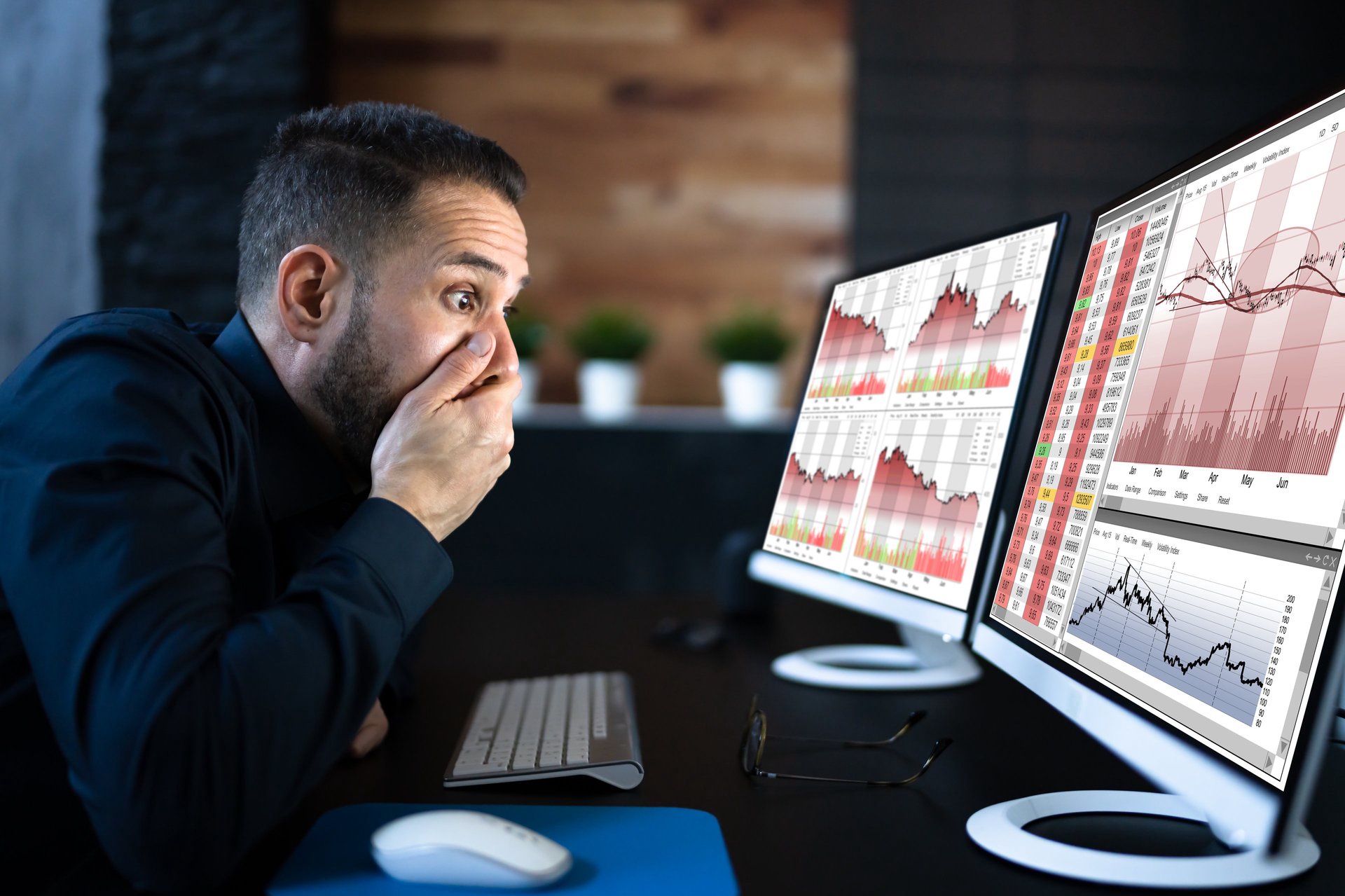 Nervous investor looking at computer screens