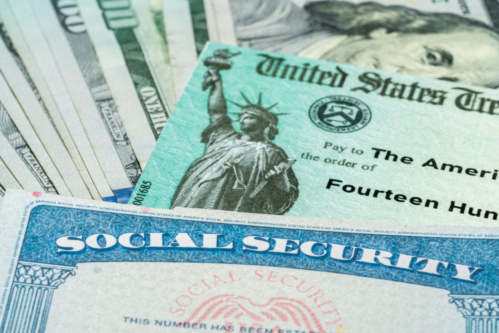 Stock image: a Social Security card lies with U.S. dollar bills.