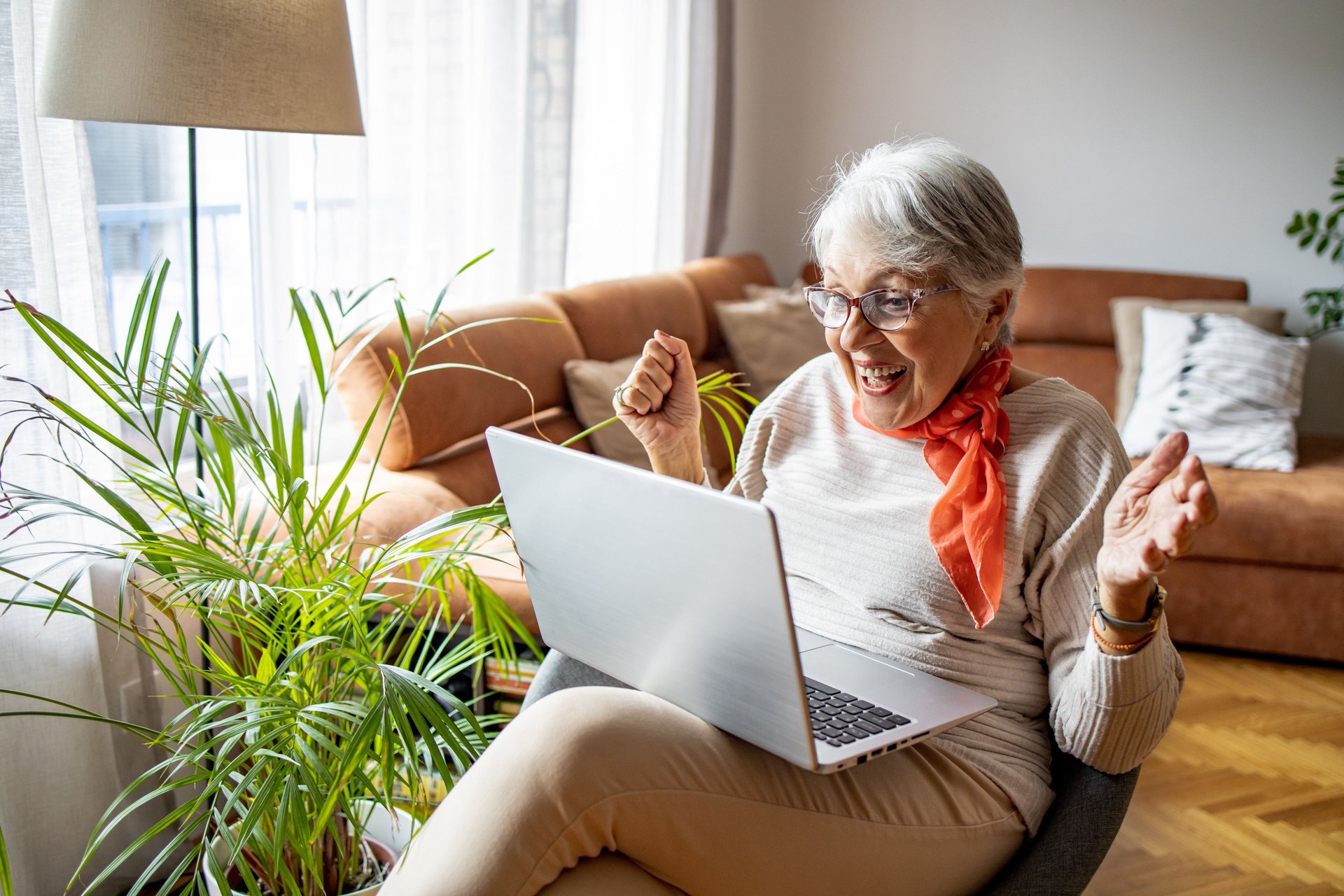 A smiling person balancing a laptop in their lap