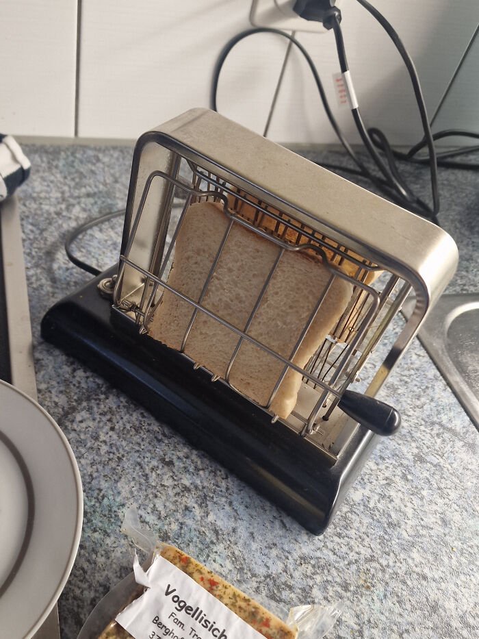 An old-fashioned metal toaster with bread inside, showcasing functional retro gadgets.
