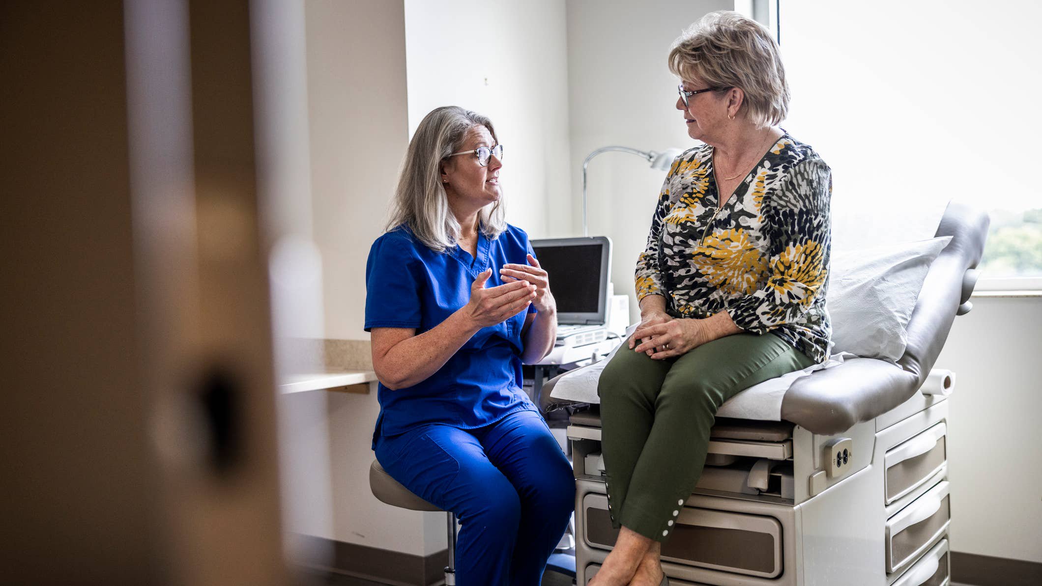 Older woman talking to doctor.