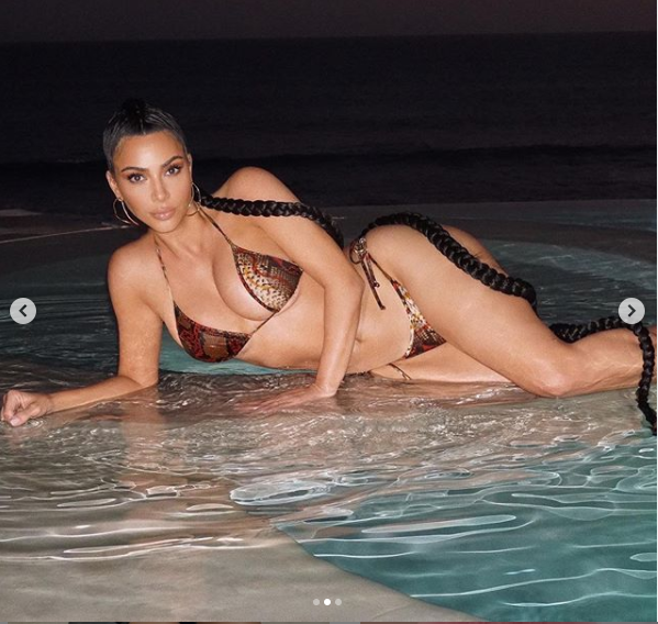 Kim Kardashian flaunts her famous curves in tiny snakeskin bikini during a racy night swim (Photos)