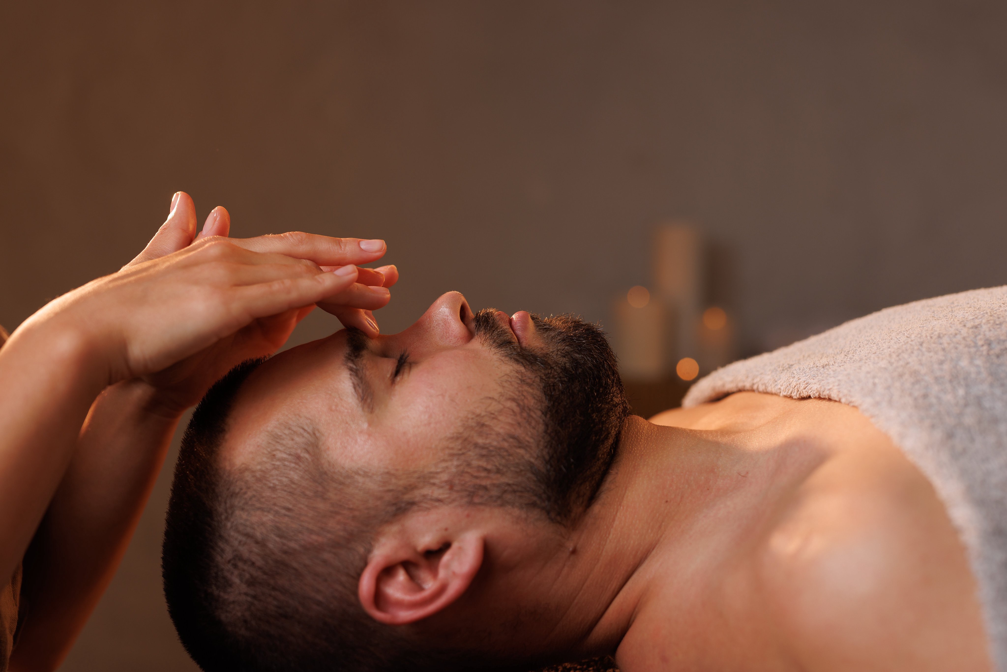 A person receiving a facial massage in a calm spa setting, promoting relaxation and wellness
