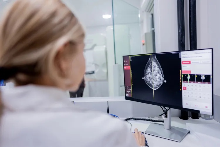 A medical professional reviewing a mammogram on a computer screen