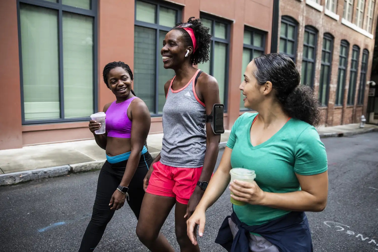 Female runners walking with coffee after a workout