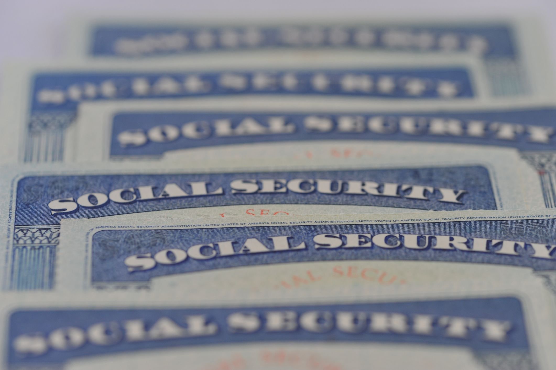 Close-up of overlapping U.S. Social Security cards arranged in rows
