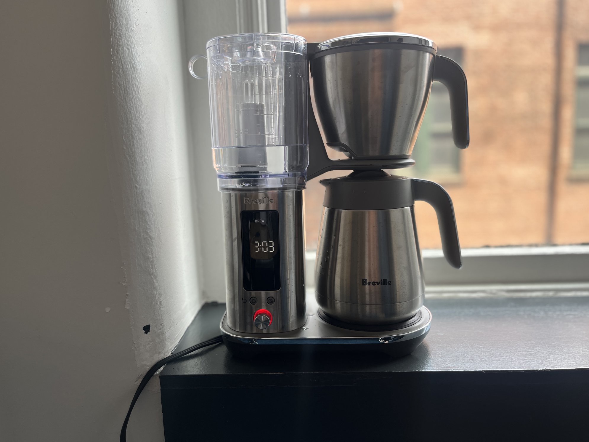 silver coffee maker on a window ledge