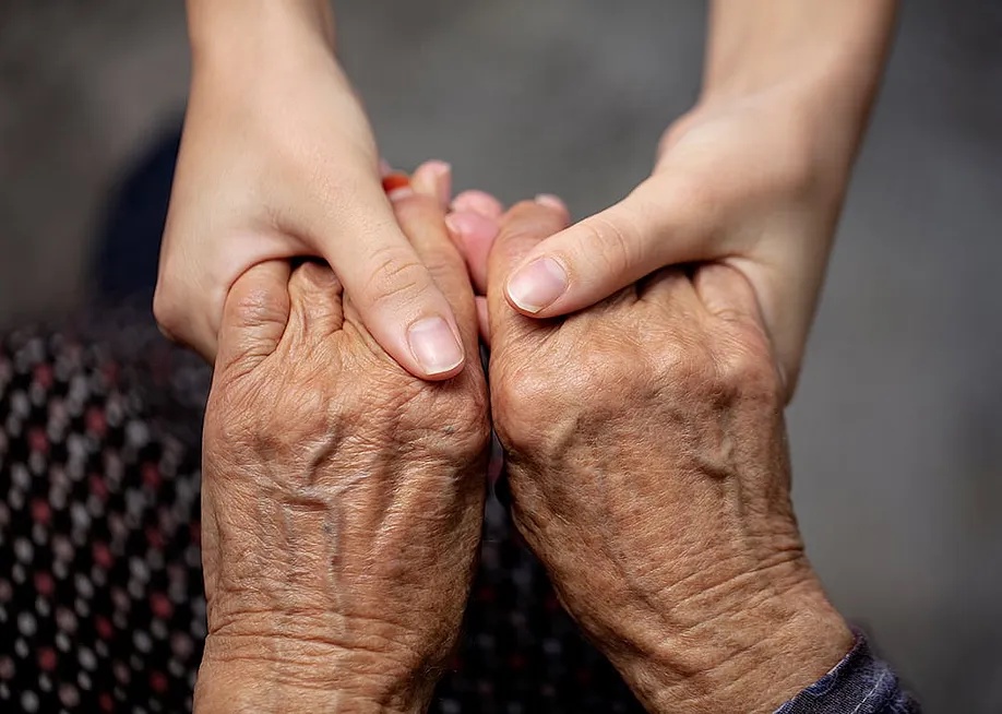Hands of an old and young persons as a concept of assisting older generation. — edahymn // Shutterstock