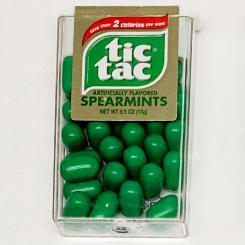 Green Tic Tac spearmint mints in a clear plastic container.