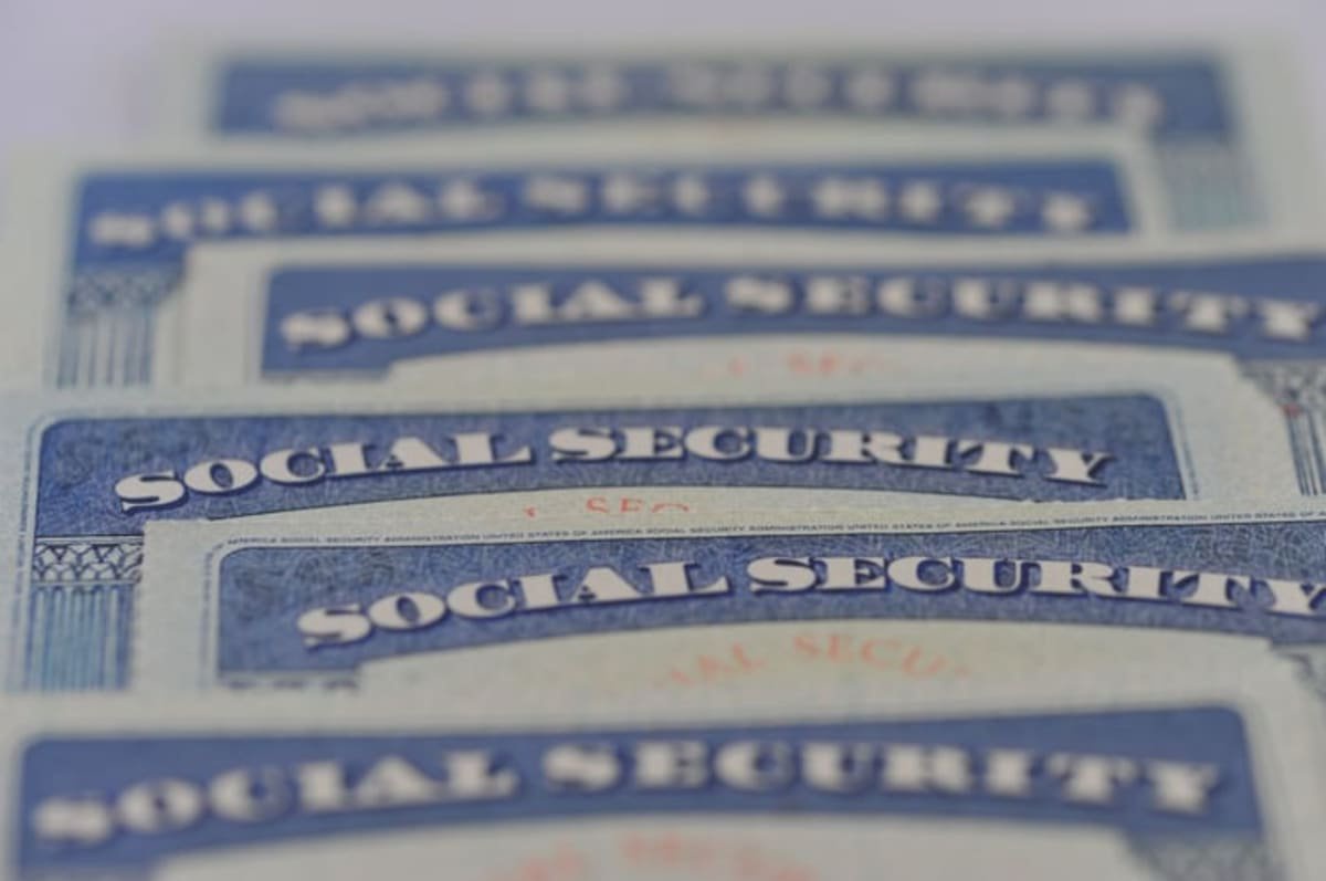 Close-up of overlapping U.S. Social Security cards arranged in rows