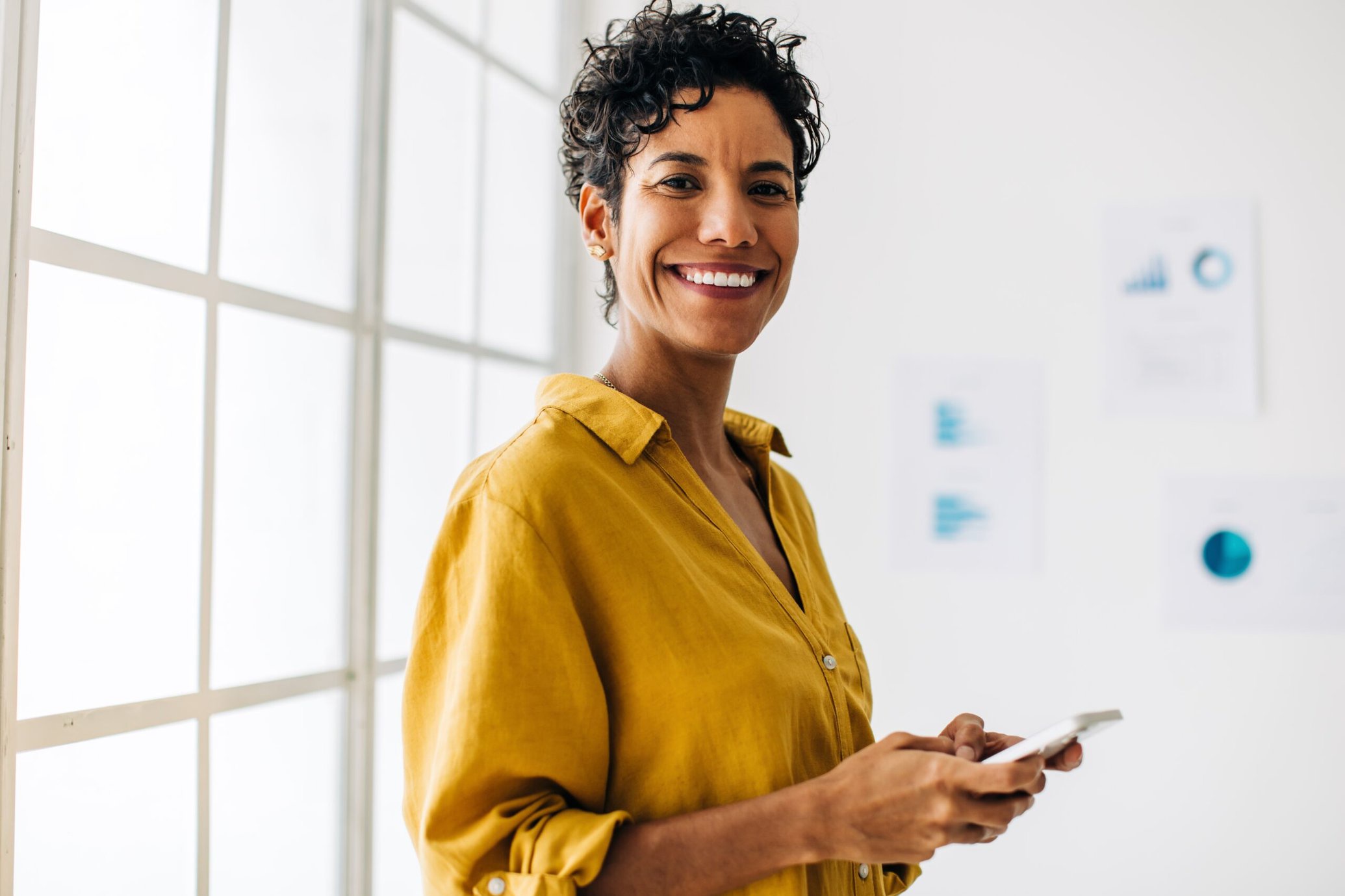 Happy middle-aged woman holding her phone