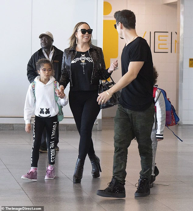 Home sweet home: Mariah Carey seemed happy to be back in the United States after a performance in Dubai as she landed at John F. Kennedy International Airport on Monday morning in New York