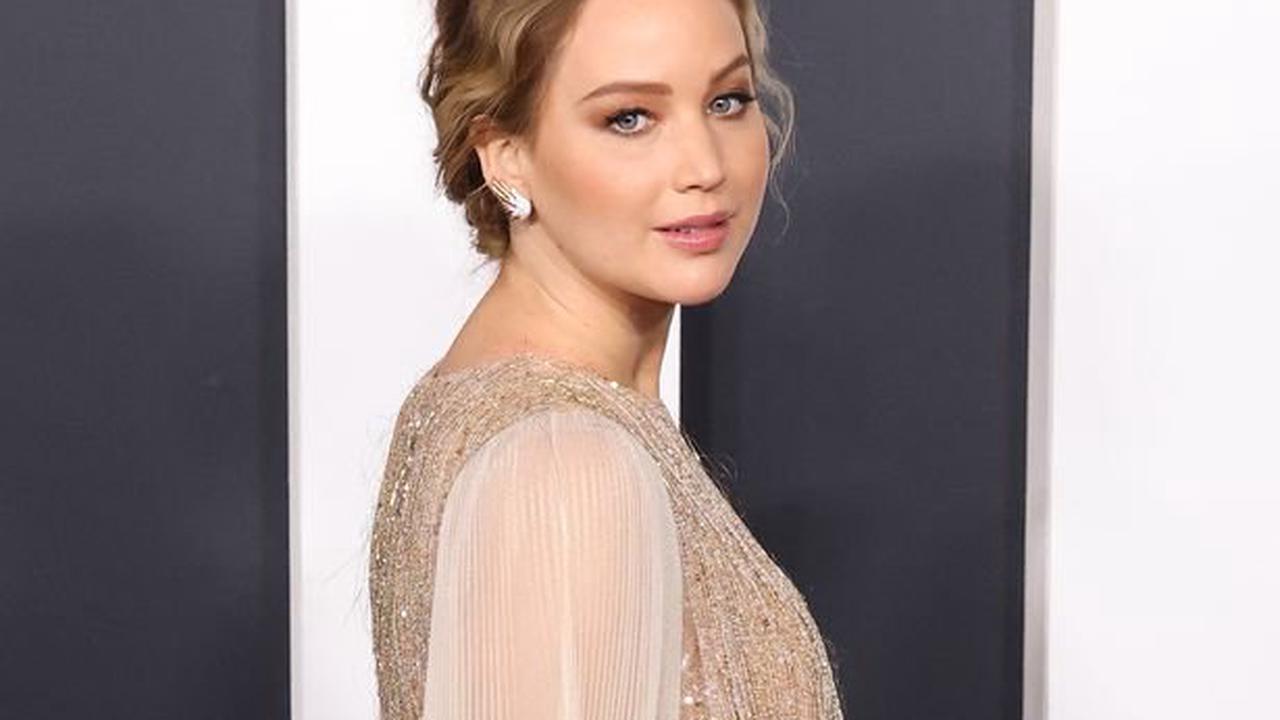 Pregnant Jennifer Lawrence wows as she shows off her baby bump in a stunning gold gown