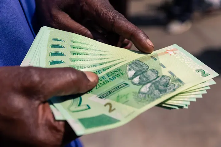 A man shows a wad of new Z$2 banknotes he received from a bank in Harare, November 12 2019. Picture: JEKESAI NJIKIZANA / AFP