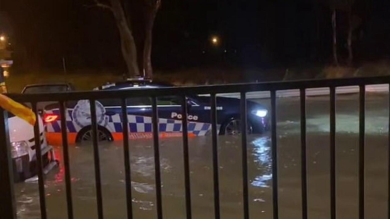 So much for 'if it's flooded, forget it:' Watch the unbelievable moment a cop car drives INTO floodwaters - despite the police's own repeated warnings