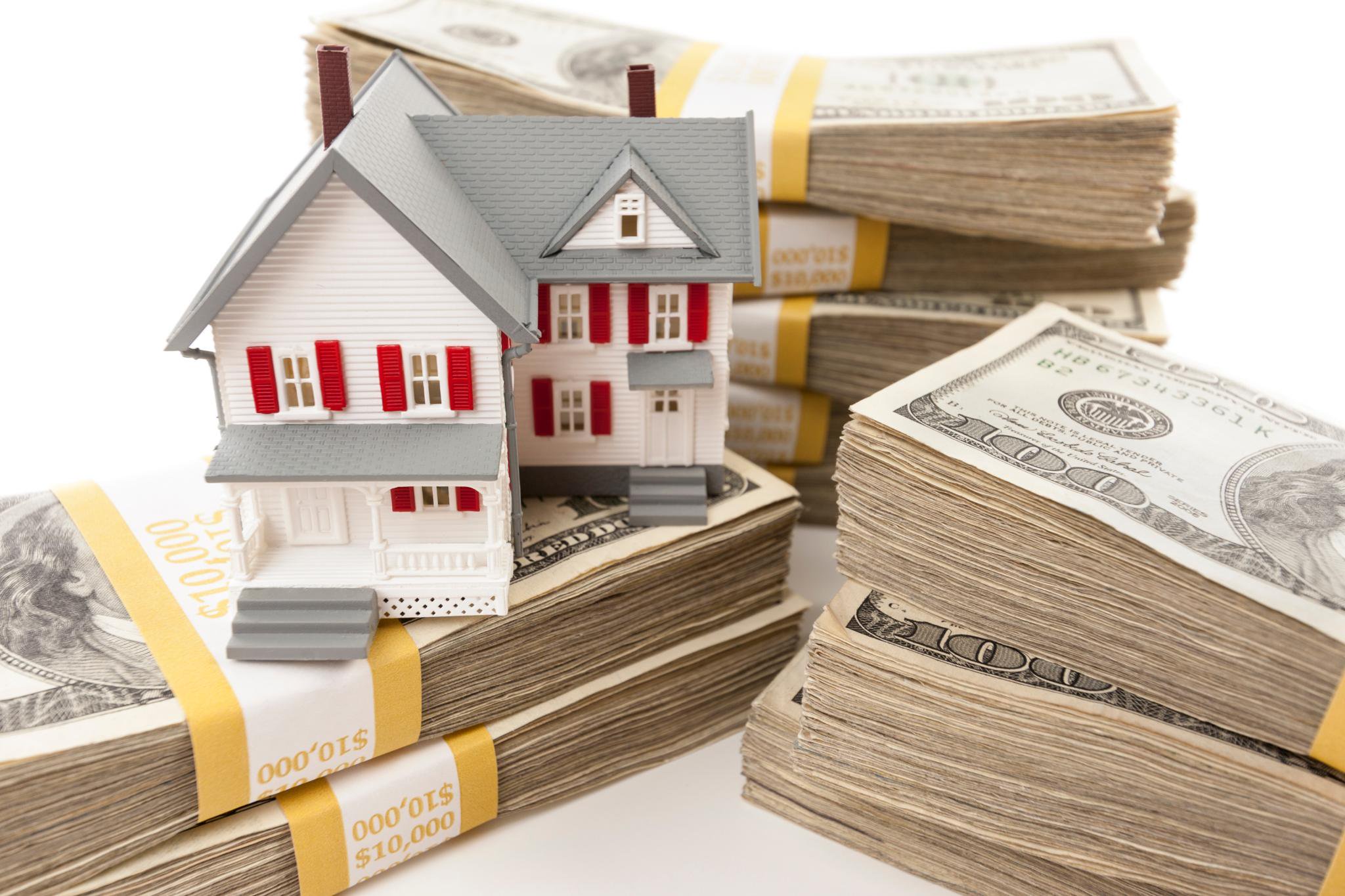 Model house on stacks of $100 bills.