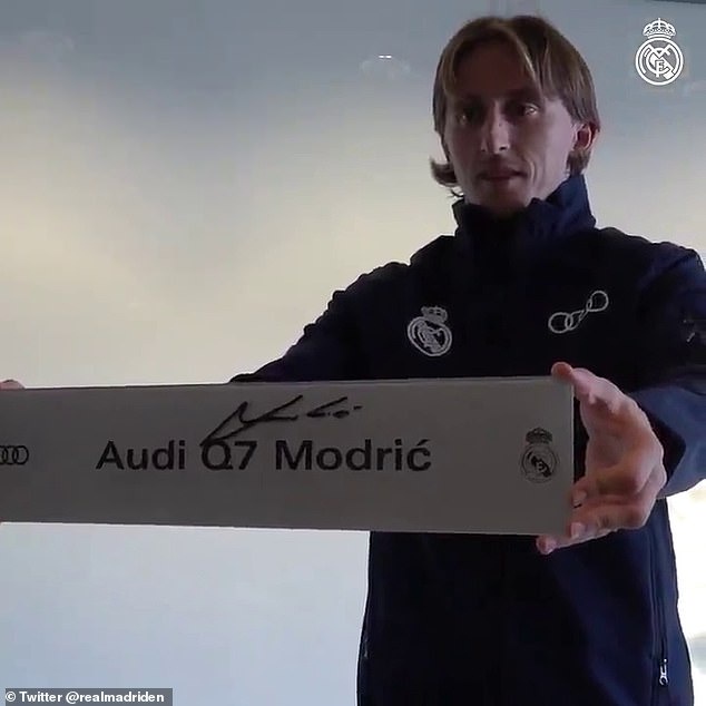 Luka Modric held up a signed new registration plate as he was handed his new Audi Q7 car
